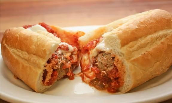 Della Torre's meatball parm hero sandwich, sliced open on a plate