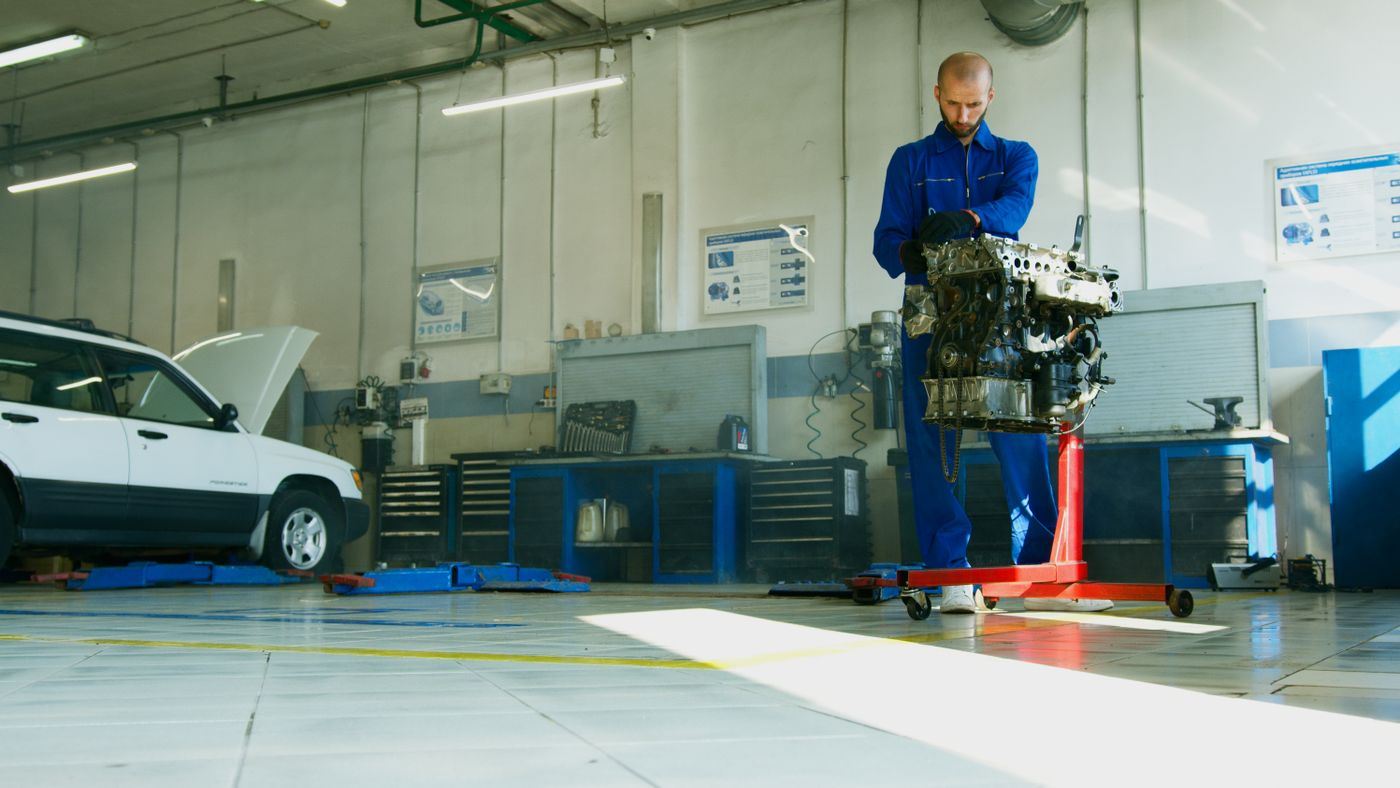 Technician working on an engine pulled from a vehicle