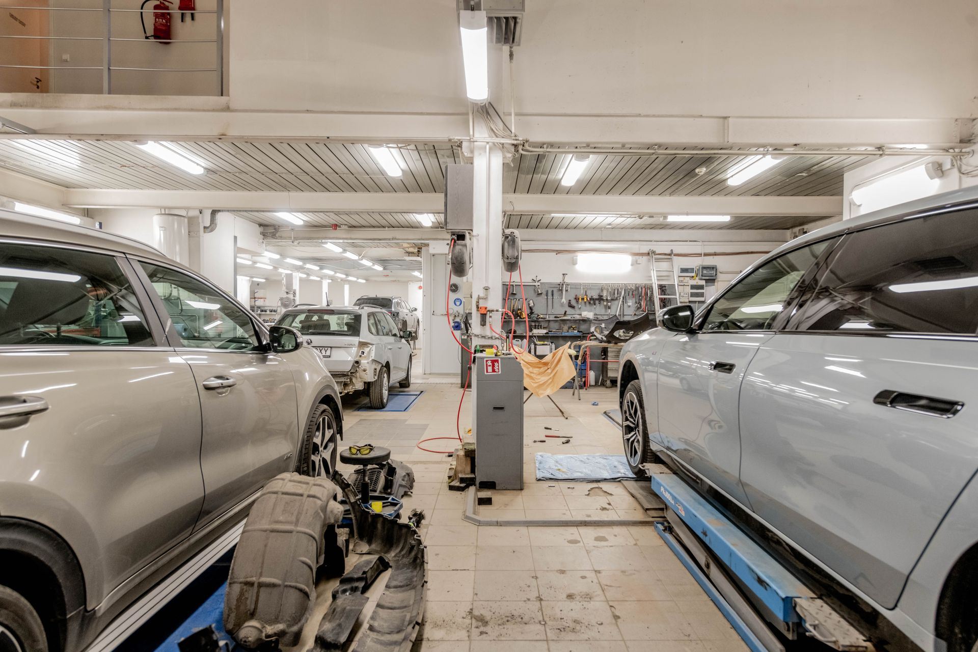 Interior of K Auto Repair's service bay in Garden Grove with vehicles up on lifts