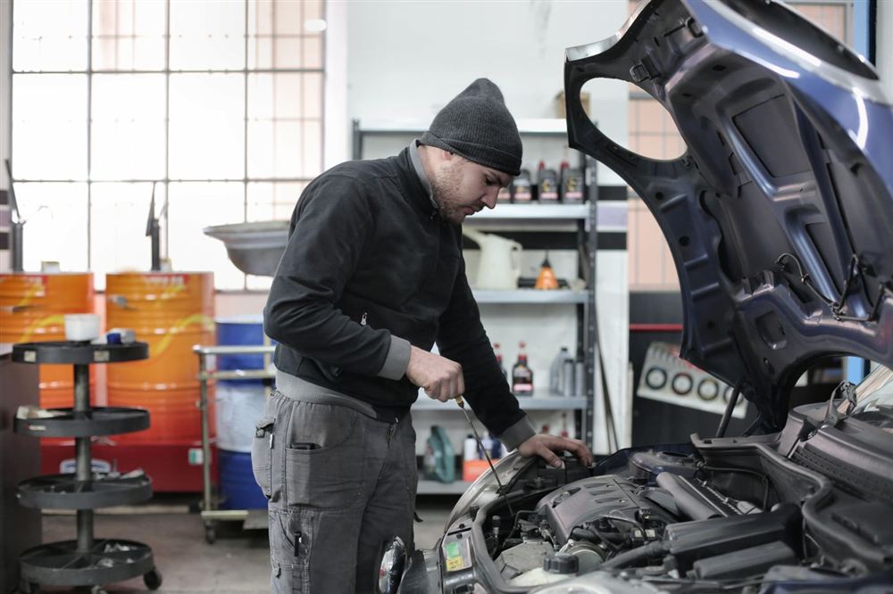 Mechanic performing an under-hood inspection