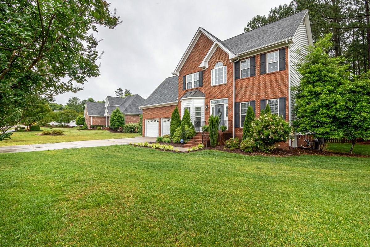 A well-maintained two-story home with a lush, freshly mowed front lawn