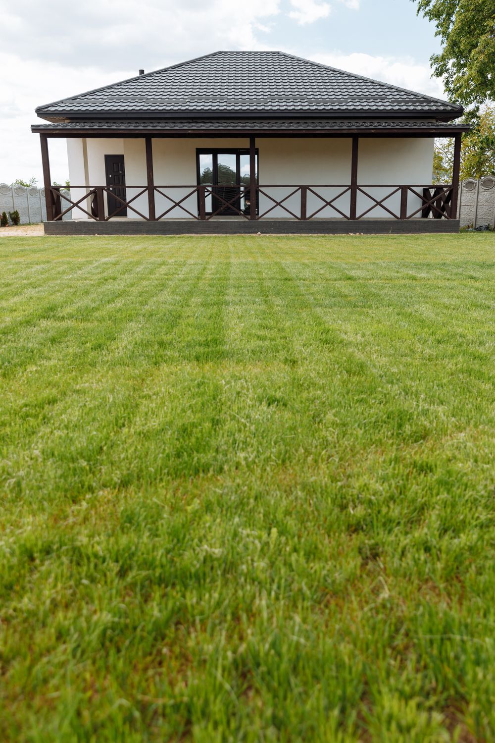 House with a neatly striped lawn leading up to the front porch